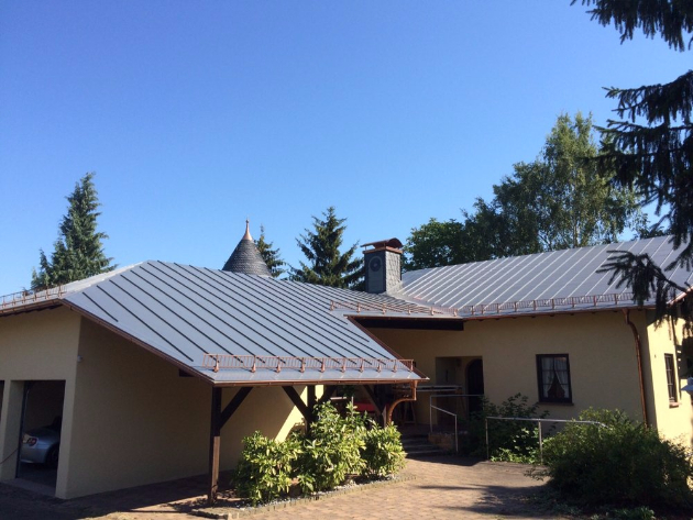 Schöne Villa mit schieferfarbenen Dachbahnen und braunen Aluminiumprofilen